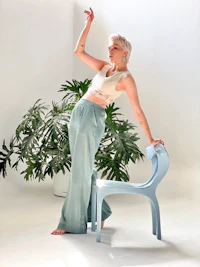 a woman posing in front of a blue chair