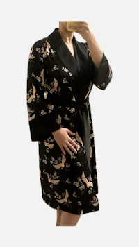 a woman is taking a selfie in a black robe